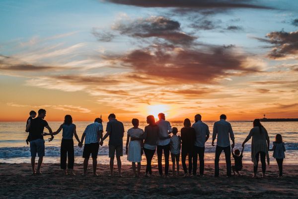Pessoas na beira da praia de mãos dadas